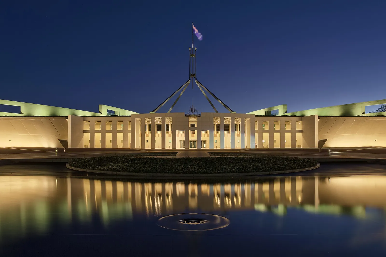 Parlamentsgebäude in Canberra mit Fahnenmast in der Abenddämmerung